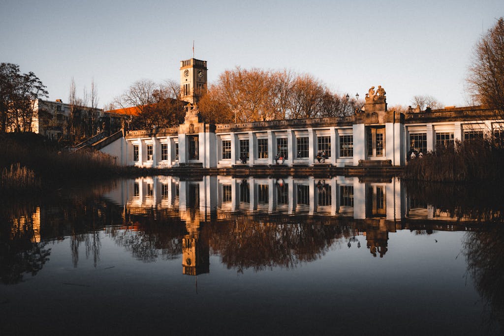 Serene reflection of historic pavilion by pond in Berlin's Rudolph-Wilde-Park.
