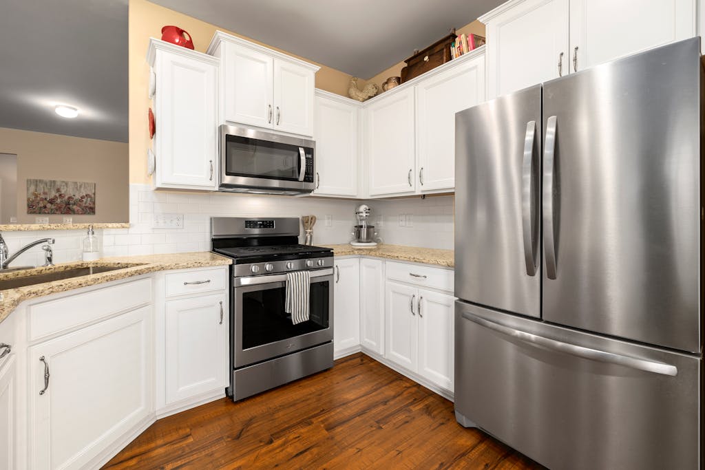 Sleek modern kitchen featuring stainless steel appliances and white cabinets.