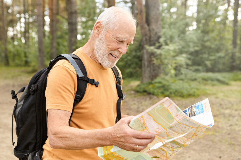If You Ignore These 8 Things as a Retiree, You Will Be Isolated and Lost 1 summertime image cheerful handsome energetic mature male pensioner with white beard holding paper map studying route while hiking with backpack outdoors alone amazing forest smiling