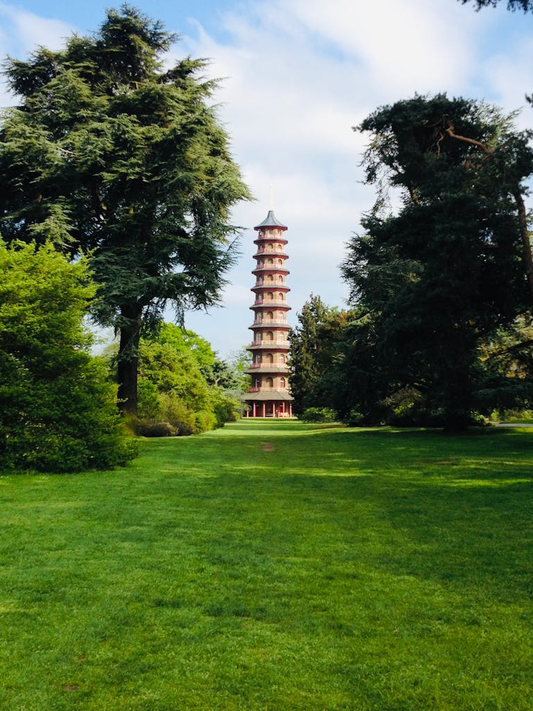 The Great Pagoda at Kew Gardens surrounded by vibrant trees and green grass.