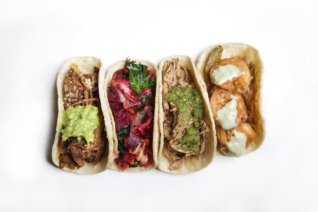 Top view of a variety of delicious tacos, showcasing diverse fillings and vibrant colors.