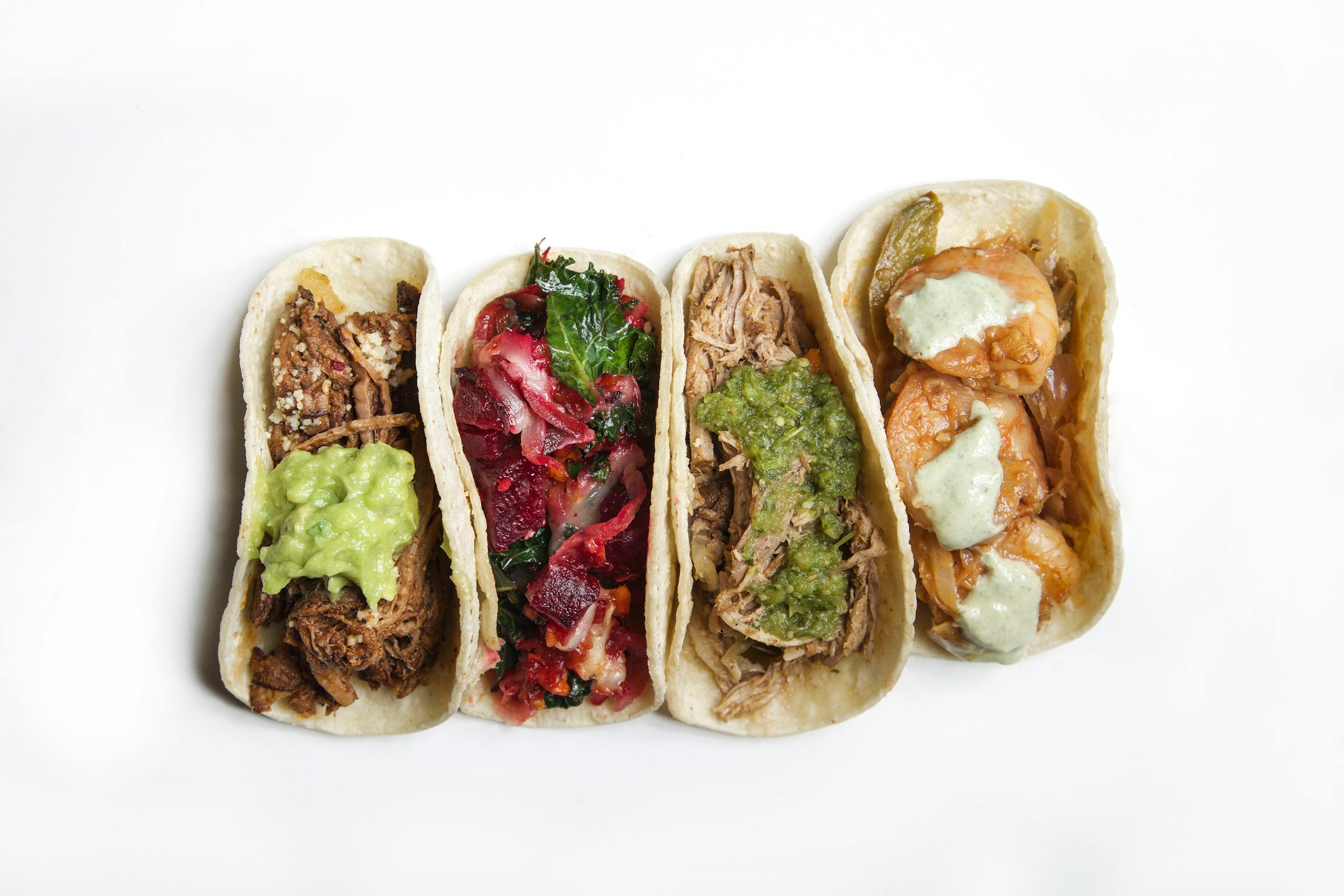 Top view of a variety of delicious tacos, showcasing diverse fillings and vibrant colors.
