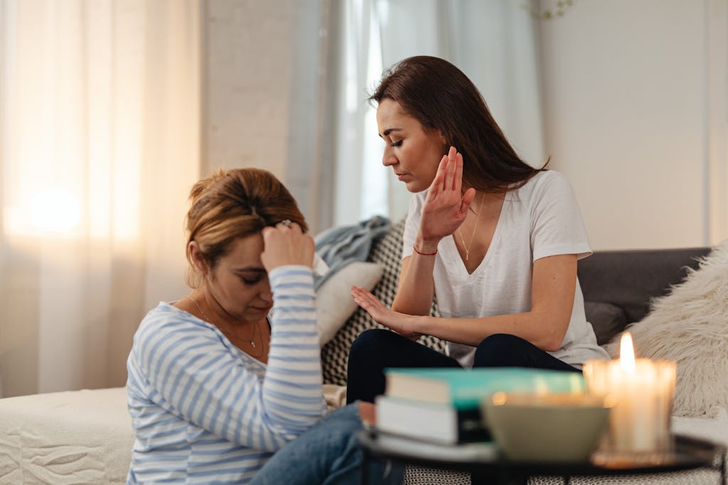 Two women in a tense emotional exchange in a cozy home setting.