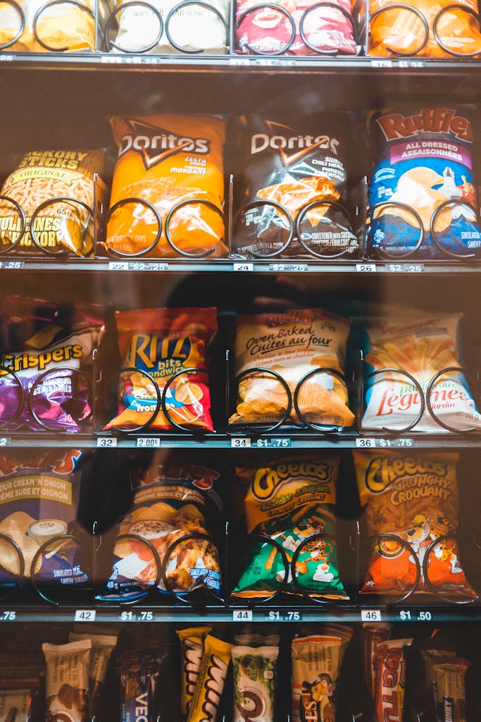 Vibrant selection of various snacks in a vending machine, featuring chips, cookies, and candies.