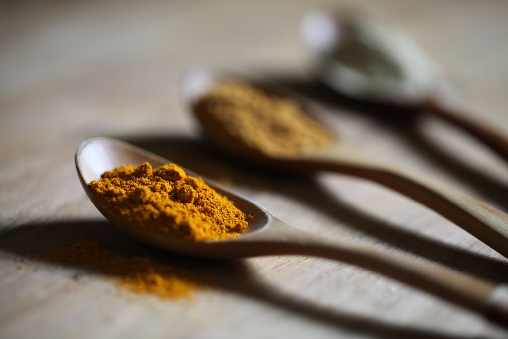 10 Superfoods That Could Be Damaging Your Health 2 Vibrant turmeric powder on a wooden spoon with a blurred background for culinary use.