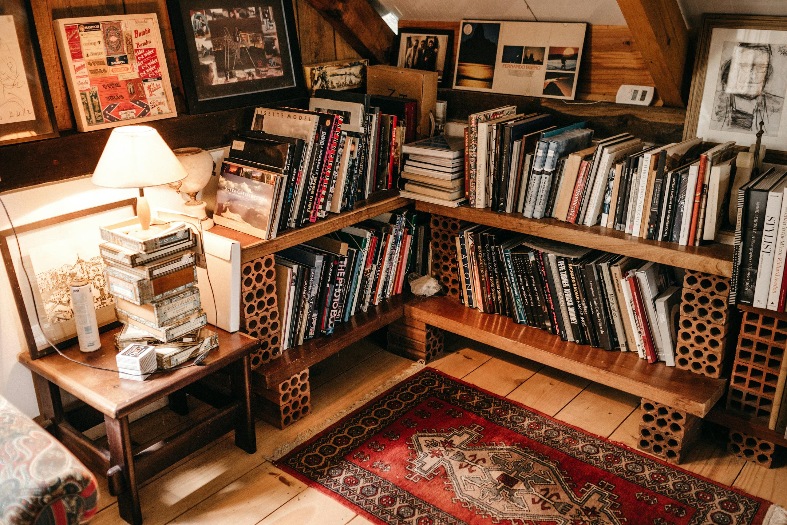 Warm and inviting home library with wooden shelves filled with books and soft lighting.