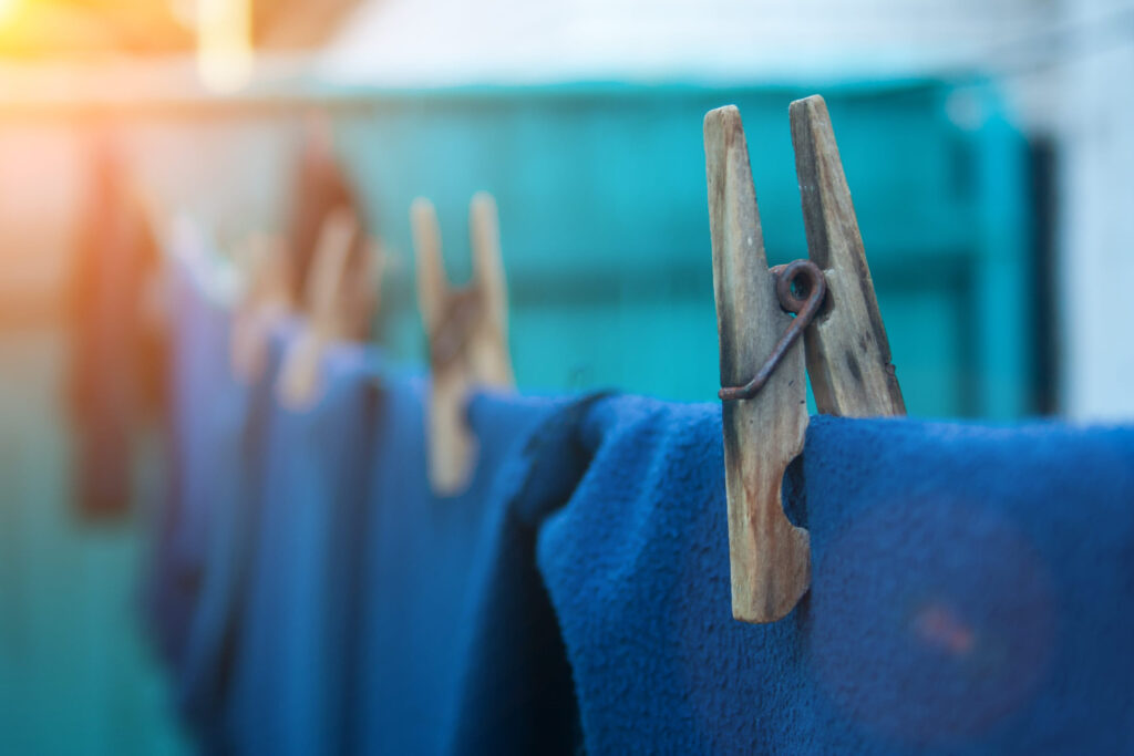 Clothes on old wooden clothespins hanging on a rope