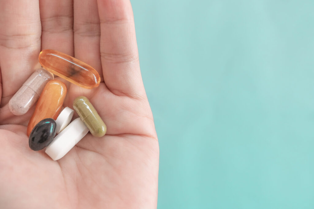 Top view of alternative organic medicine or herbal vitamin supplement capsule tablet on woman hand with copyspace background. Concept of healthy eating lifestyle.