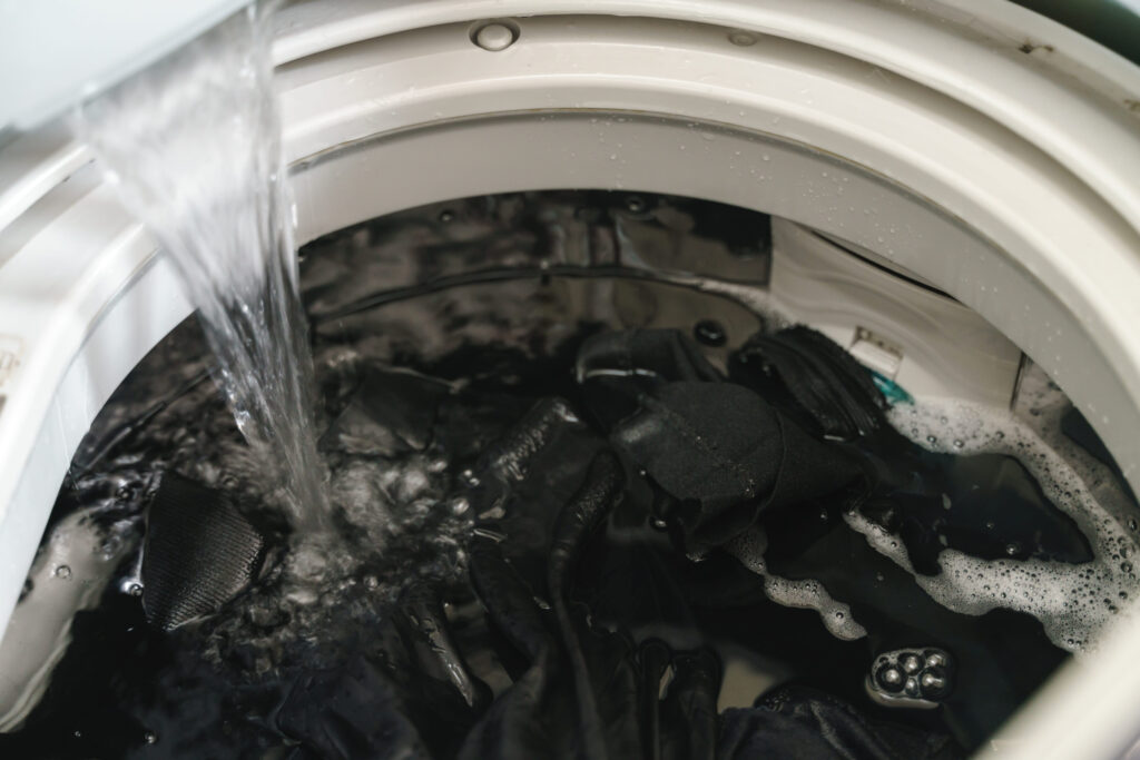 Laundry clothes in top loading washing machine with detergent water dissolution