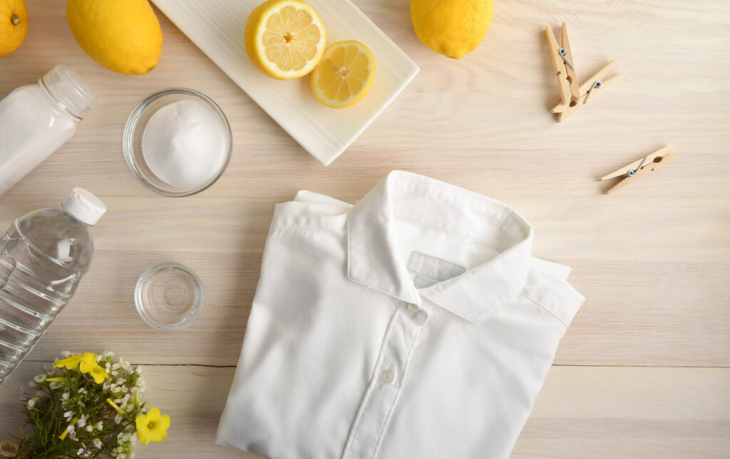 Alternative clothes cleaning products on wooden table with clothes and isolated background. Frontview. Landscape composition.