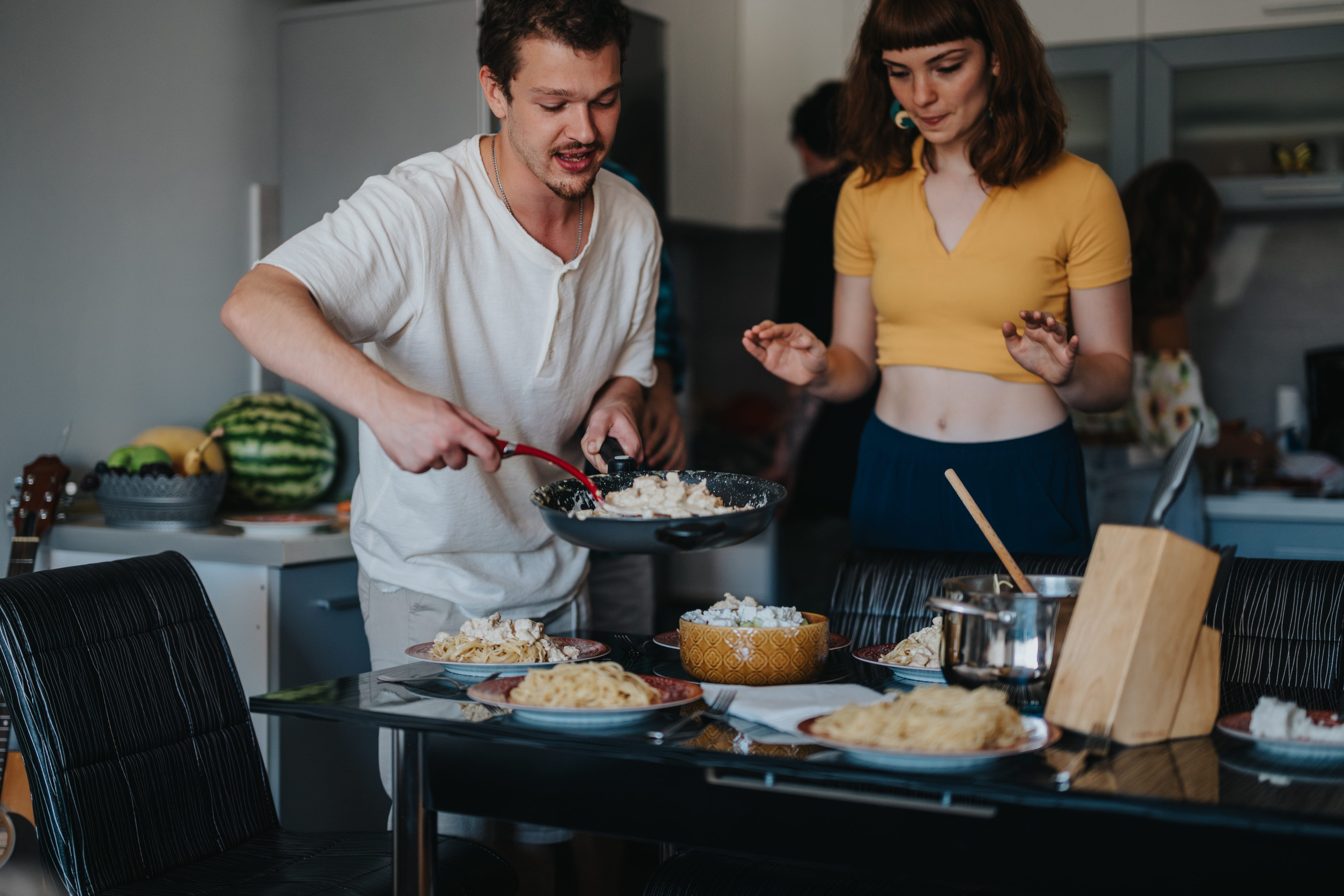 Friends cooking dinner together in a cozy kitchen setting