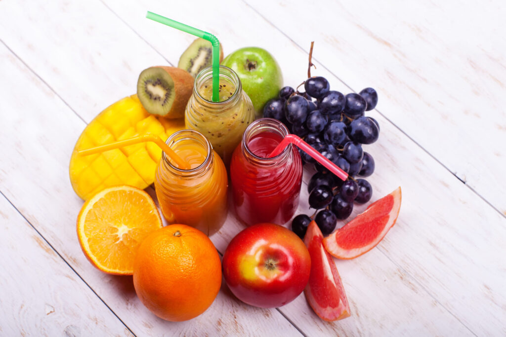 Row Fresh Juices Smoothie Three Bottles Red Green Orange Fruits Vitamins Healthy Concept on white.
