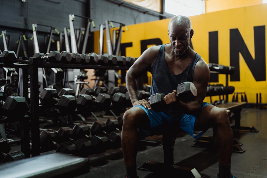 If You Keep Making These 10 Exercise Mistakes, You’ll Never Get Fit 3 A determined man lifting dumbbells in an urban gym setting, showcasing strength and focus.