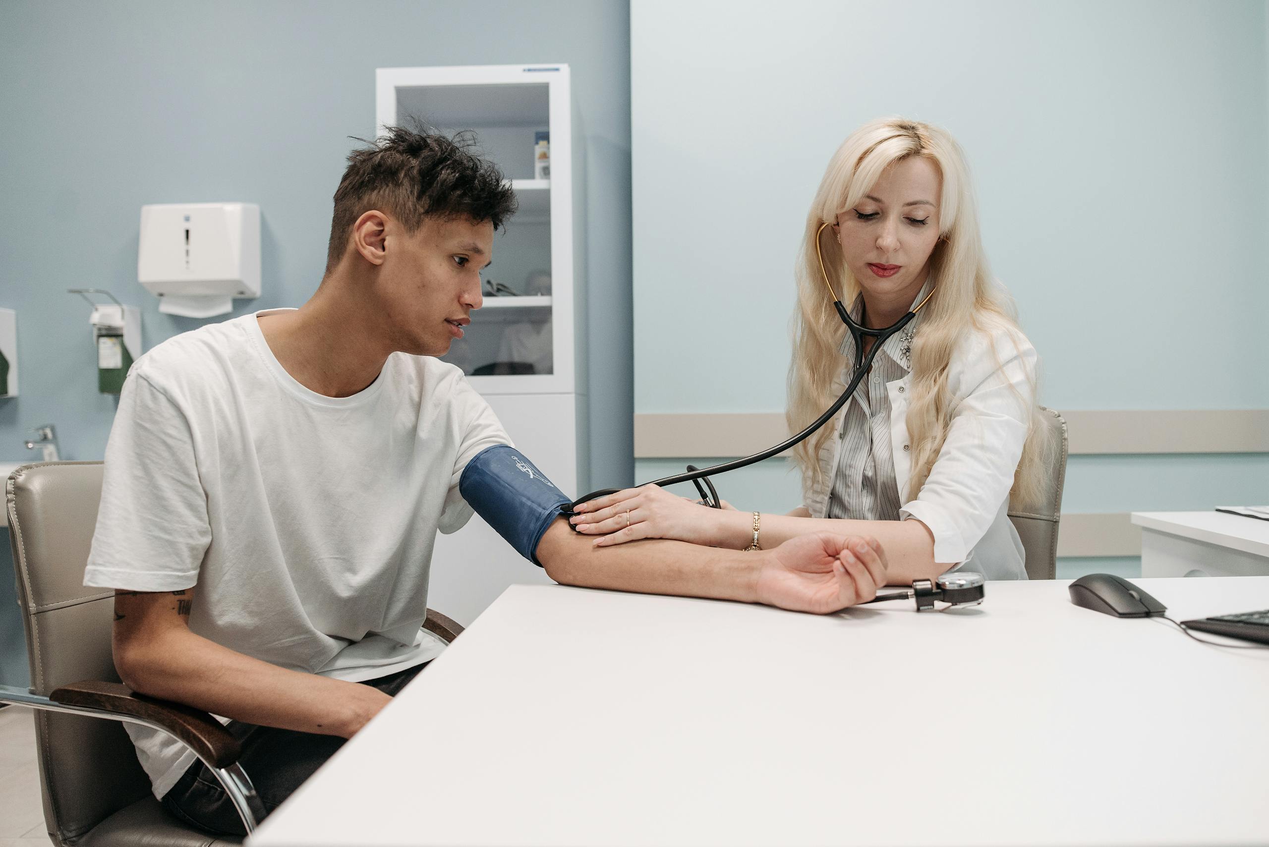 A doctor measures a patient's blood pressure in a clinic setting, focusing on healthcare and wellness.