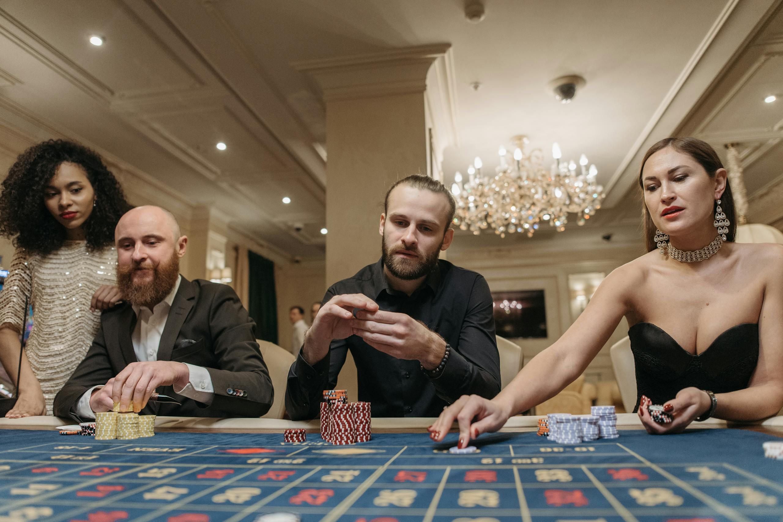 A group of stylish adults enjoying a night of gambling at a casino table, showcasing opulence and luxury.