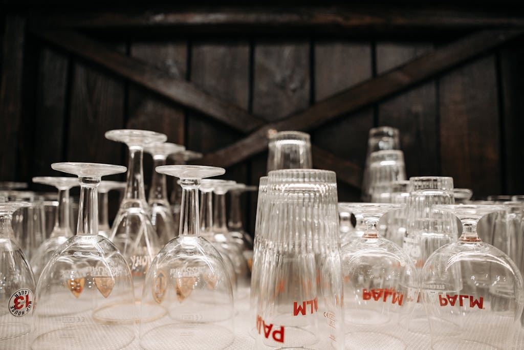 A variety of upside-down glasses in a rustic bar setting, ready for use.