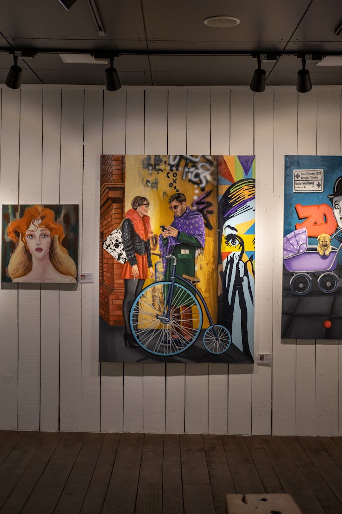A vibrant collection of paintings showcased in a modern art gallery, highlighting various styles and themes.