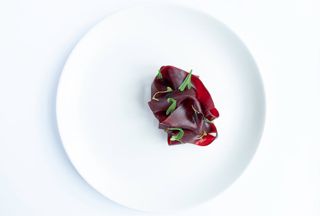 Artistic presentation of sliced beets on a white plate, capturing minimalist food styling.