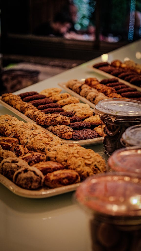 Assorted cookies arranged on trays in a bakery setting, perfect for dessert lovers.