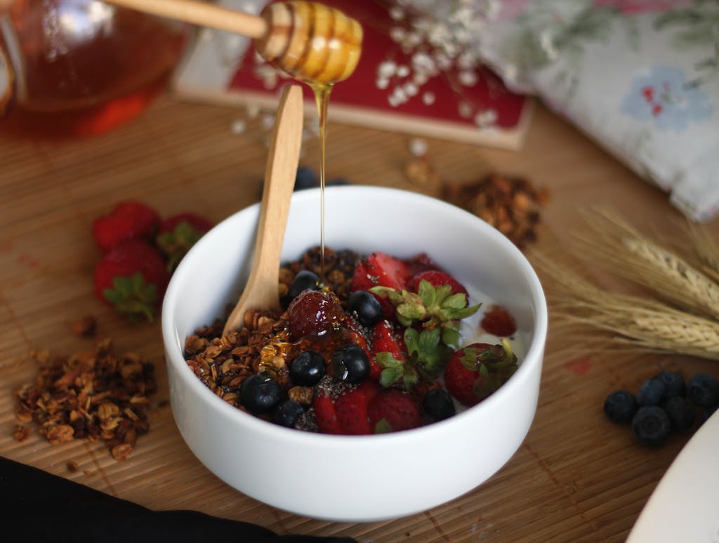 Delicious breakfast bowl topped with fresh berries, granola, and a drizzle of honey.