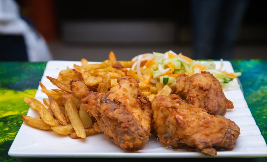 Enjoy a tasty fried chicken meal with crispy fries and fresh salad, perfect for any occasion.