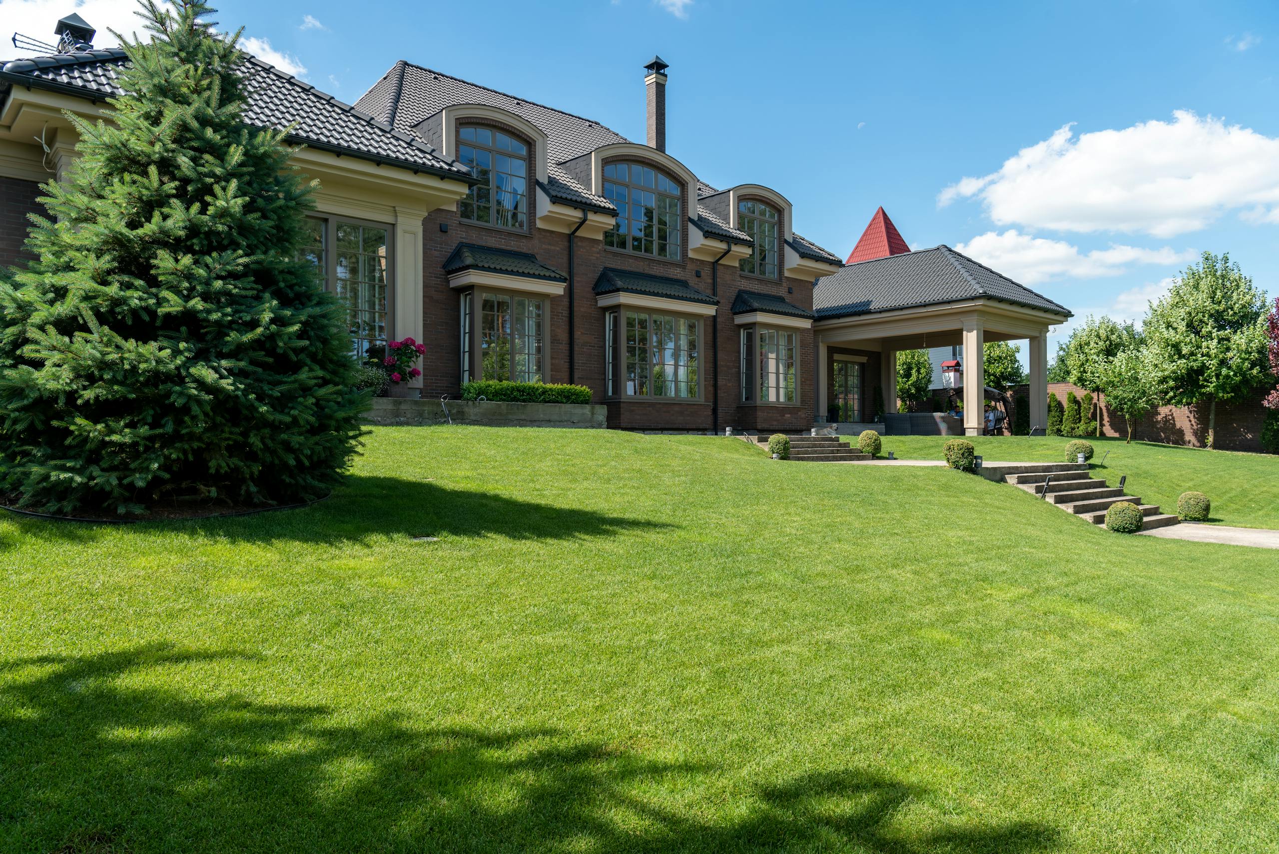 Luxury estate with manicured lawn and modern architectural design on a sunny day.