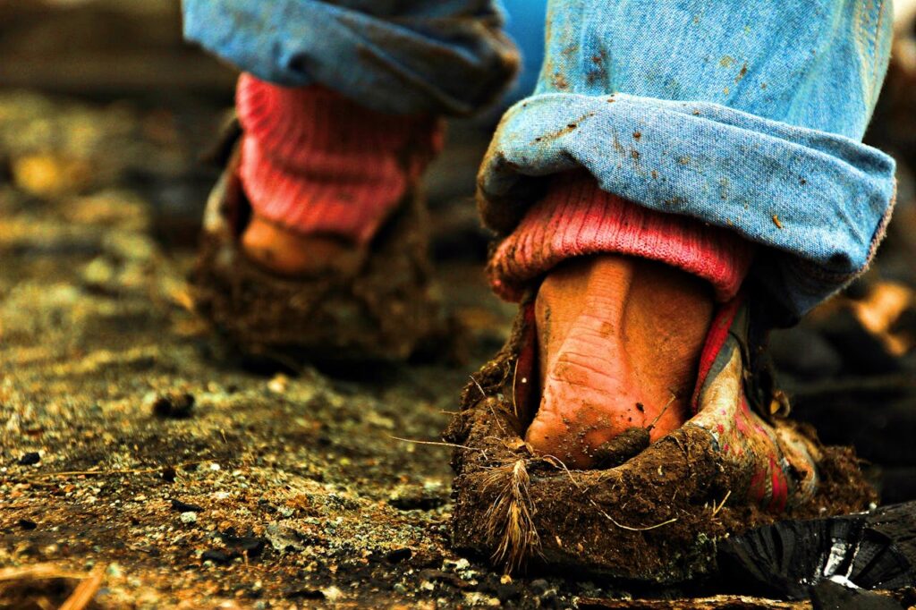 close-up-of-muddy-shoes-on-rural-pathway-