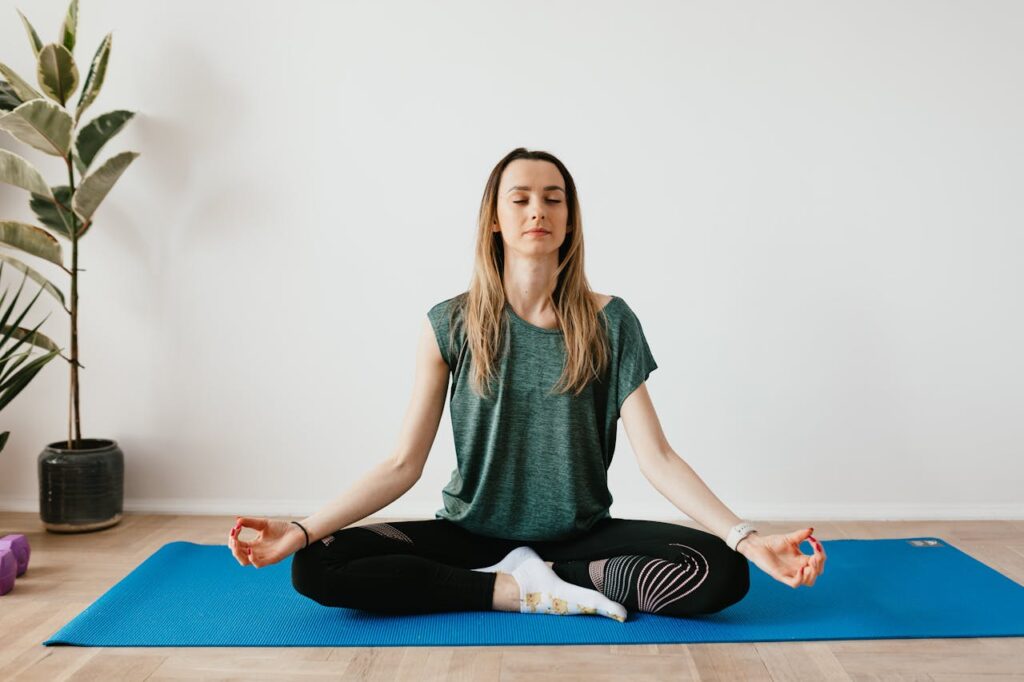 peaceful-lady-sitting-in-padmasana-pose-while-meditating-on-mat