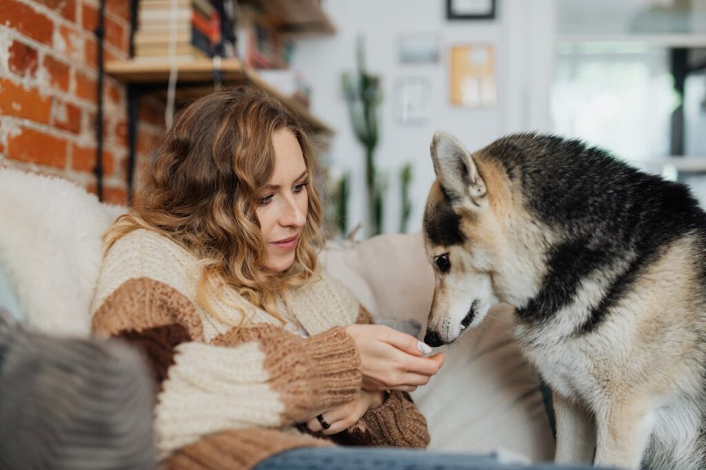 /female-owner-with-her-dog-sitting-on-a-sofa-