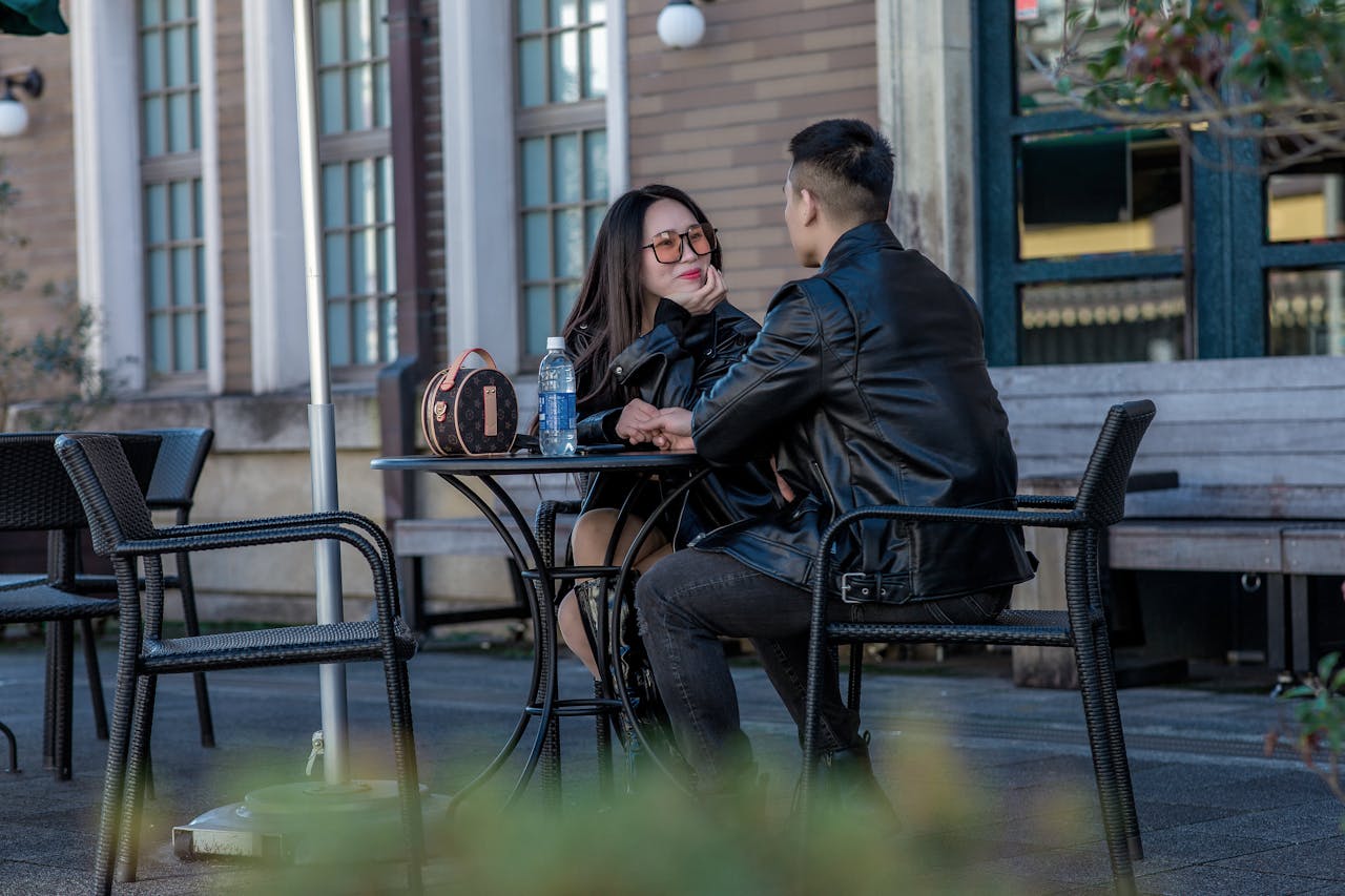 /photo-of-a-couple-in-leather-jackets-sitting-on-black-chairs-