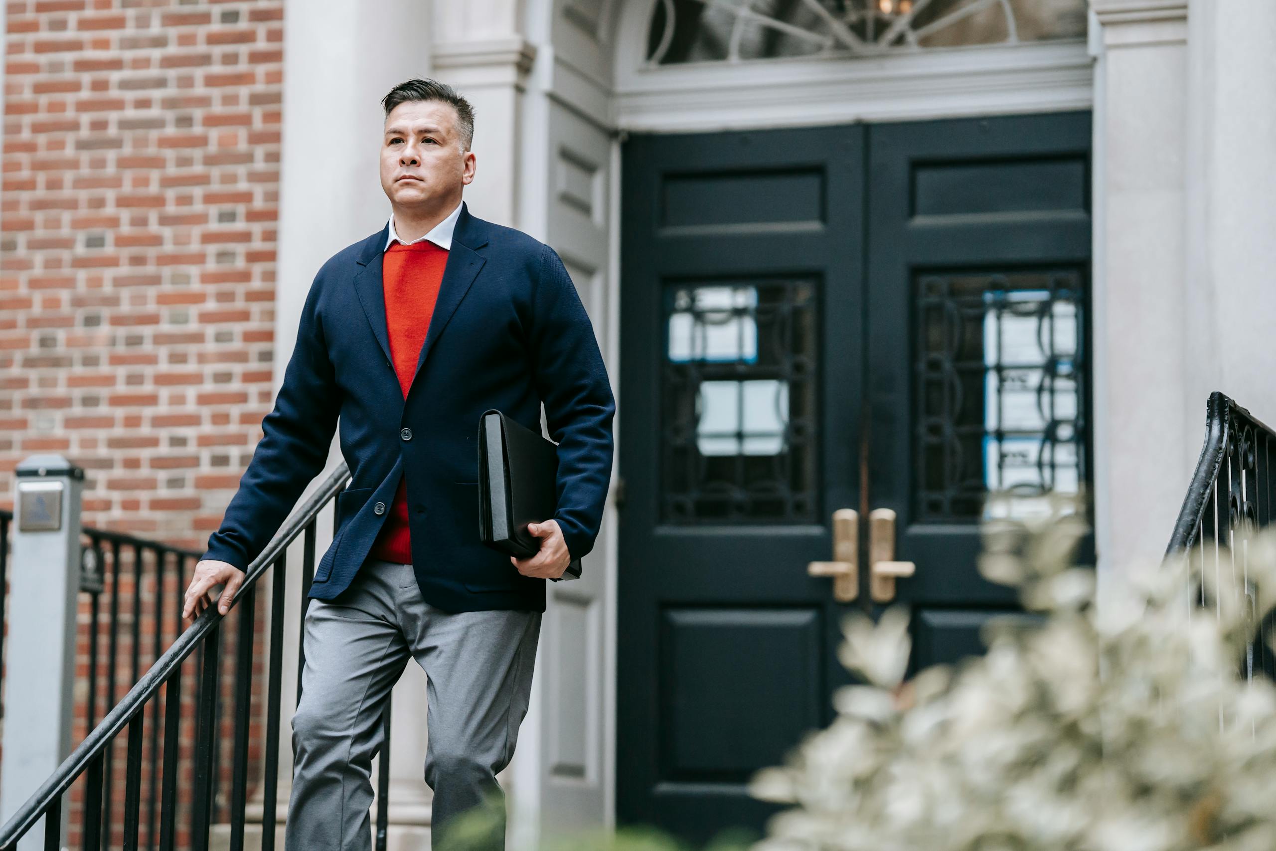 Professional man in stylish attire walking outside a building, displaying confidence.