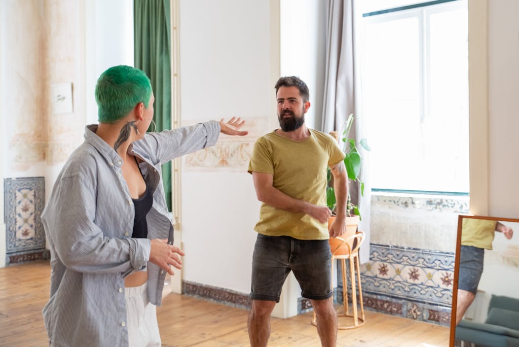 Two adults casually interact indoors in a Portuguese home with traditional decor.