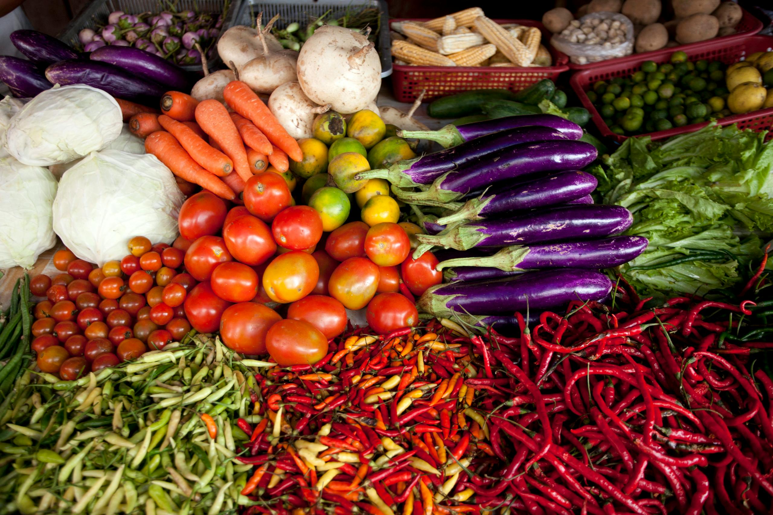 Vibrant selection of fresh vegetables arranged at an outdoor market stall.