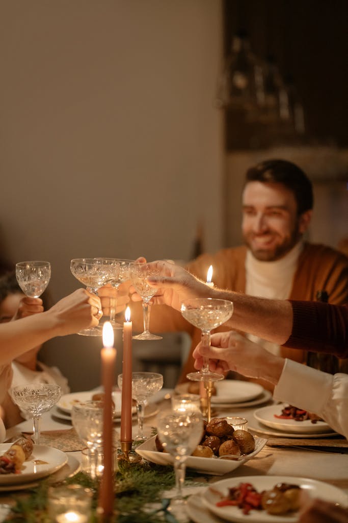 Warm and festive dinner atmosphere with friends toasting around a table.
