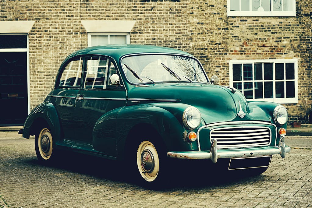 A classic Morris Minor parked outside a brick building in Ely, UK. Vintage charm captured outdoors.