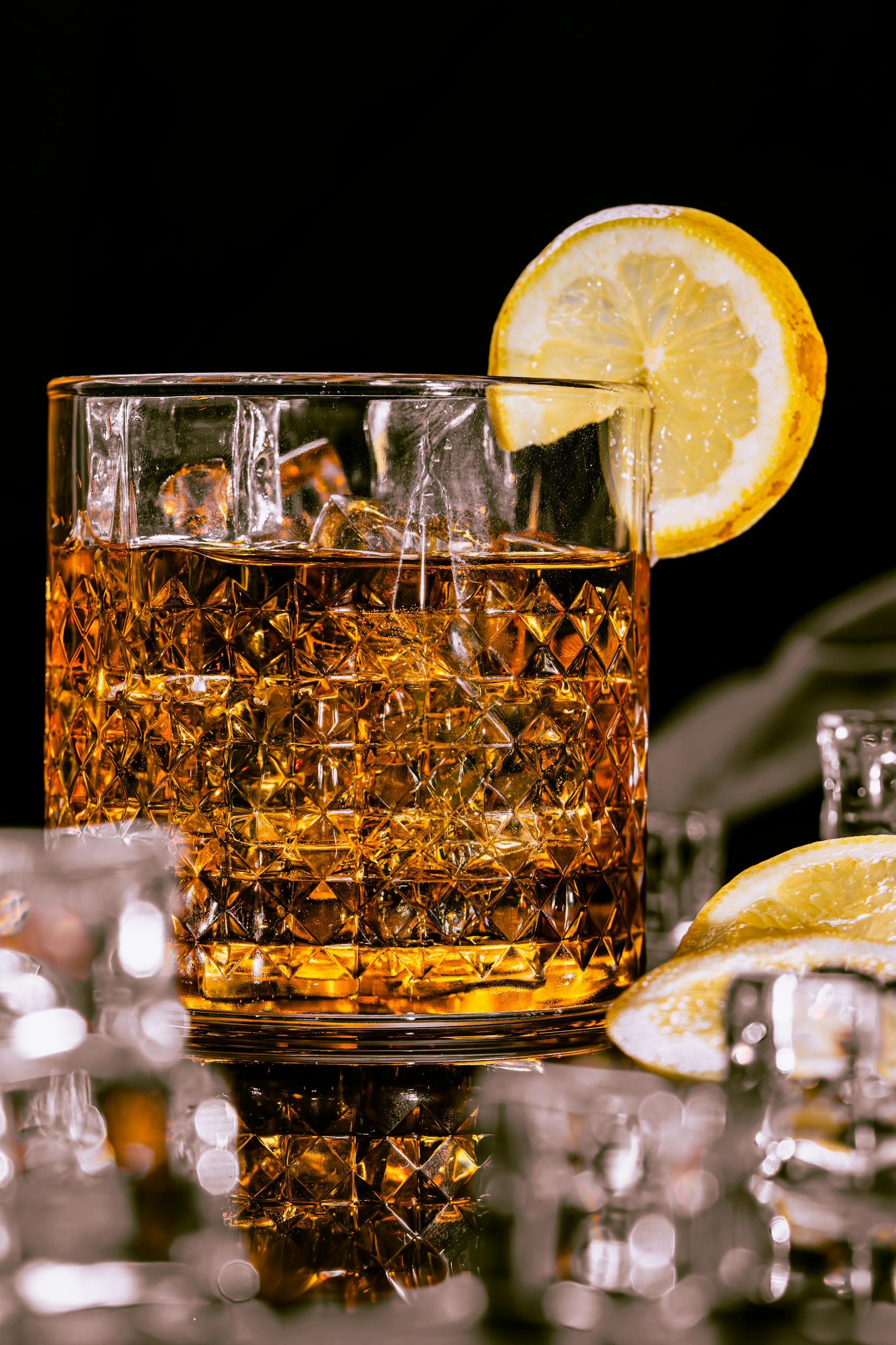A classic whiskey cocktail served in a crystal glass with lemon garnish, ideal for nightlife scenes.