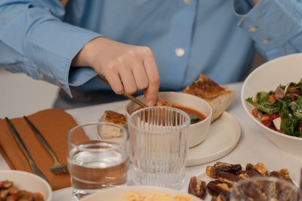 A close-up of a dining setup featuring soup, salad, and elegant tableware, creating a refined dining atmosphere.