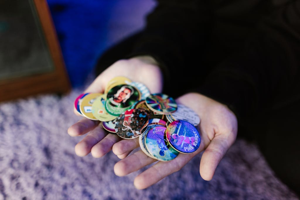 A close-up of hands displaying a vibrant collection of vintage button pins.