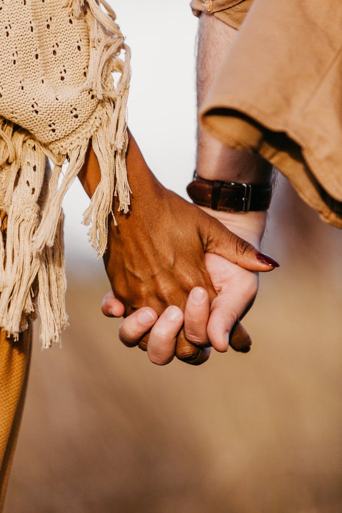 A close-up shot of a diverse couple holding hands, symbolizing unity and love.