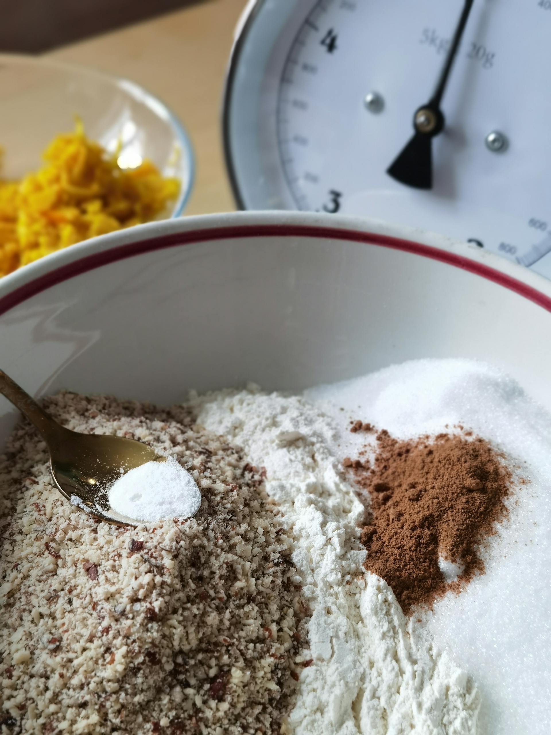 A detailed close-up of almond flour, sugar, cinnamon, and baking powder with a kitchen scale.