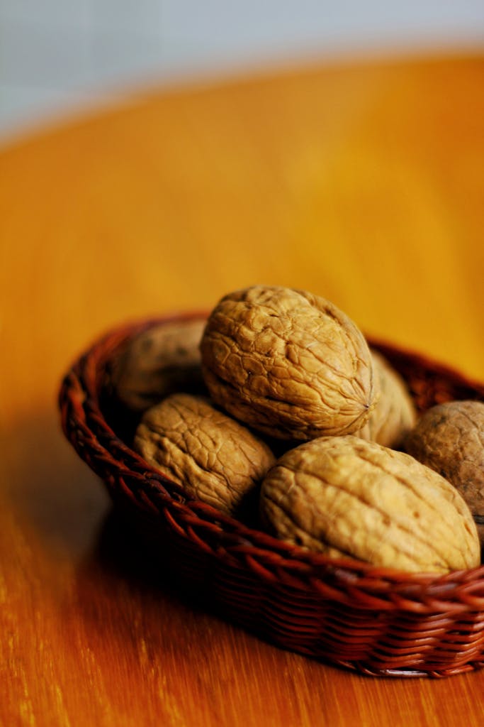 A detailed shot of walnuts in a basket on a wooden table, providing a rustic feel.