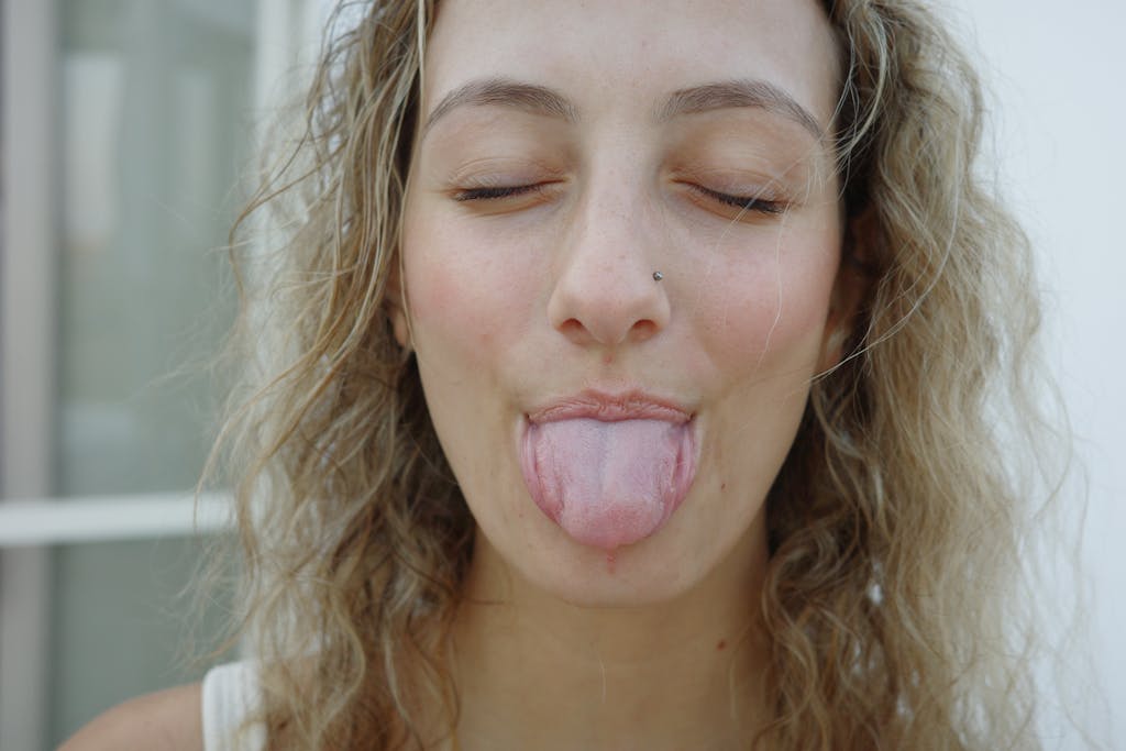 A fun portrait of a young woman sticking out her tongue playfully in Paros, Greece.