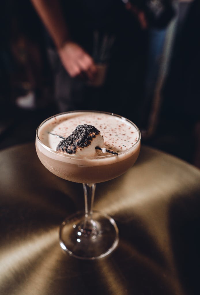 A luxurious chocolate cocktail topped with whipped cream served in an elegant glass.