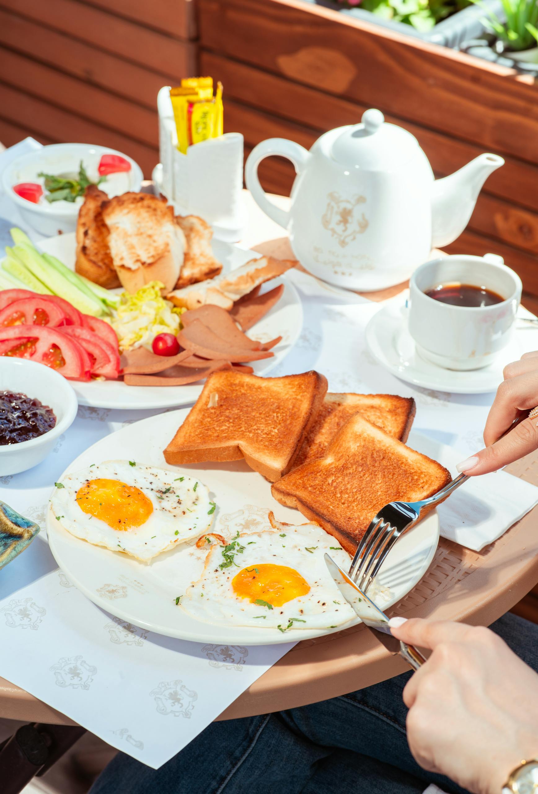 A vibrant breakfast scene with eggs, toast, and tea outdoors in Baghdad, Iraq.