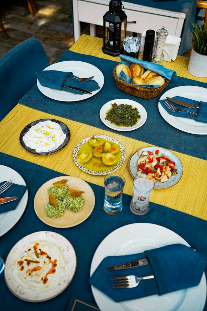 A vibrant Middle Eastern meal arranged elegantly with diverse dishes and breads on a blue-themed table setting.