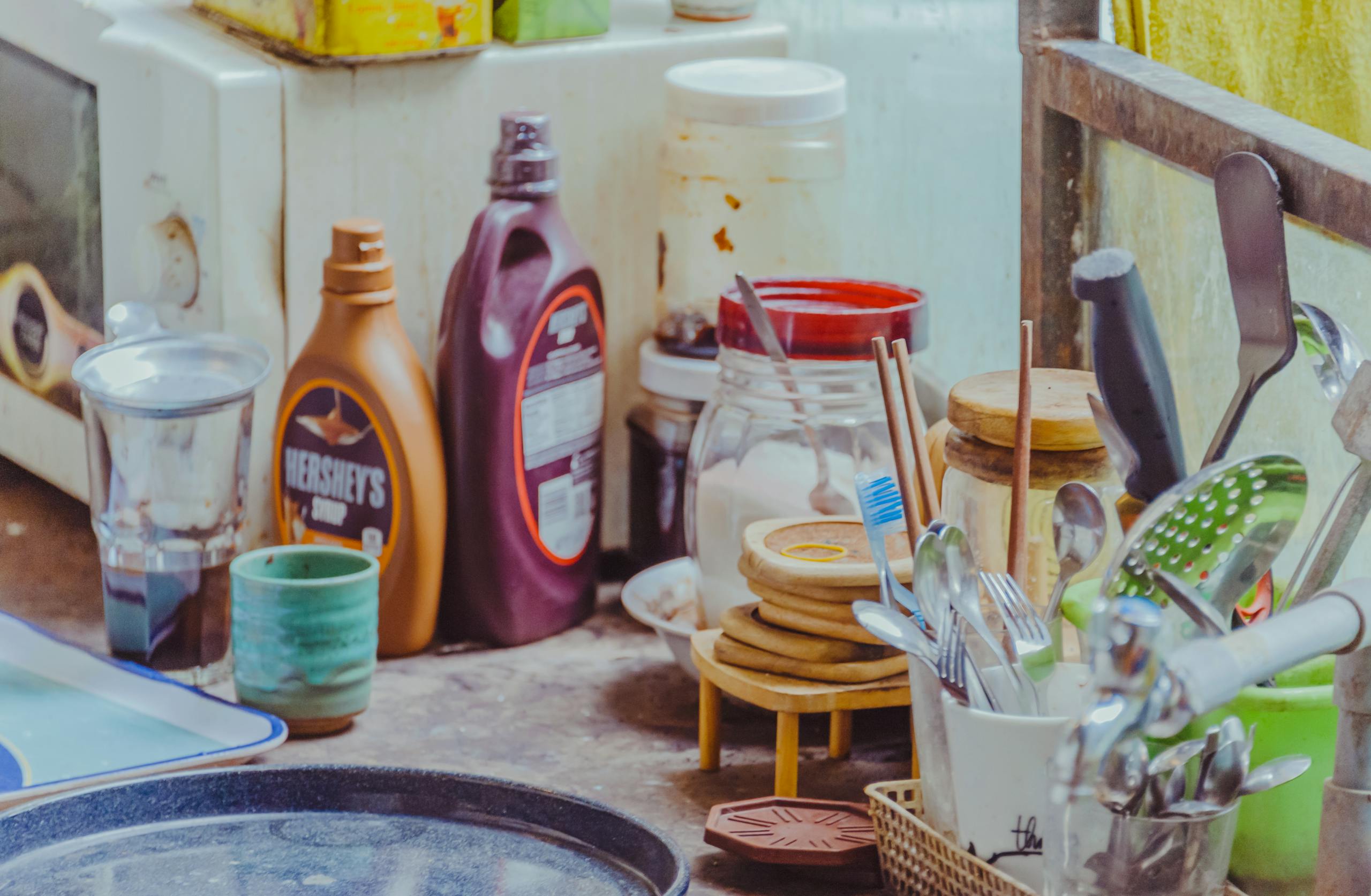 A well-equipped kitchen counter with utensils, jars, and condiment bottles.