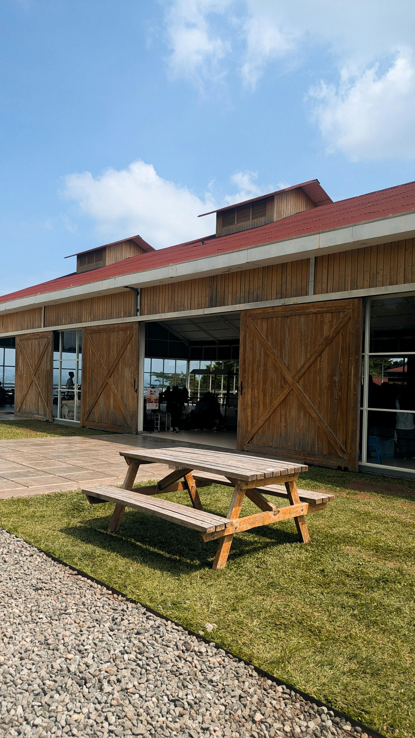 A wooden barn with a picnic table outside under a clear blue sky.