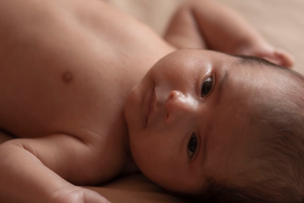 Adorable close-up of a newborn baby lying down, capturing innocence and tenderness.
