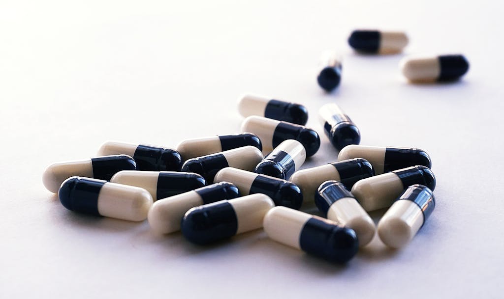 Assorted capsules scattered on a white surface. Healthcare and medicine concept image.