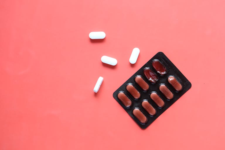 Blister pack with tablets on a vibrant red surface, perfect for health-related themes.